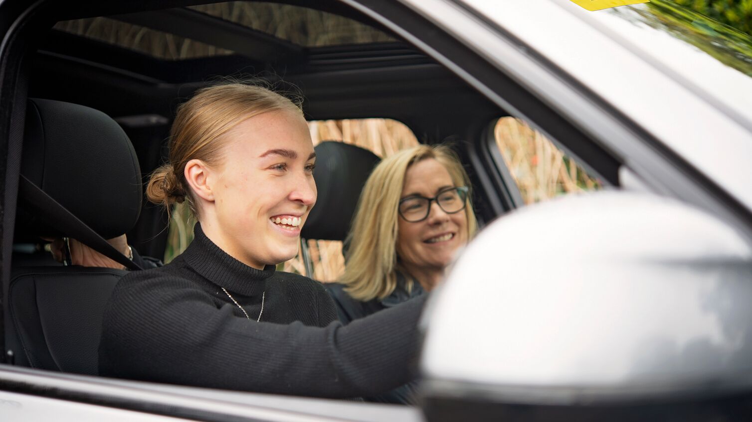 Mother and daughter, in the kitchen, taking driving lessons outdoors, winter time. L-plates.