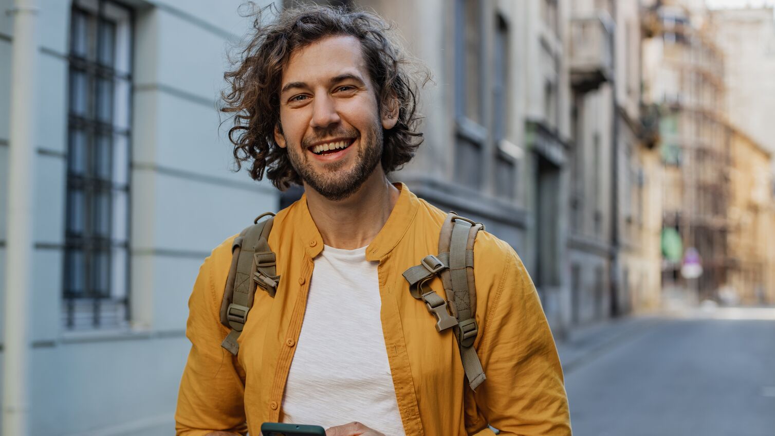 Young man walking on the street and smiling