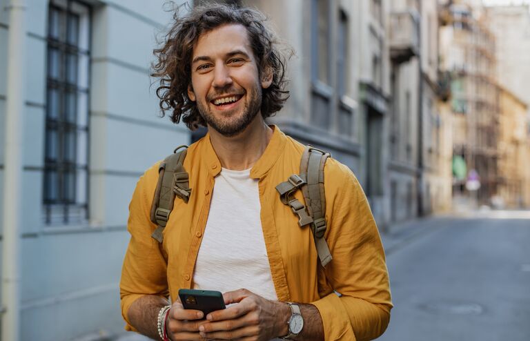 Young man walking on the street and smiling