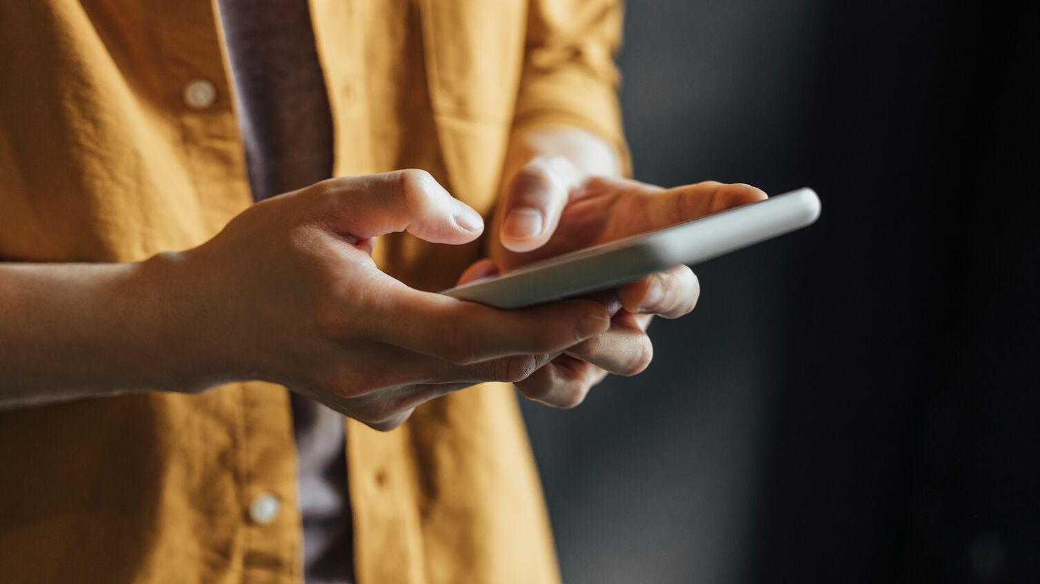 Anonymous Man Wearing a Yellow Shirt Using Modern Technology, a Close Up