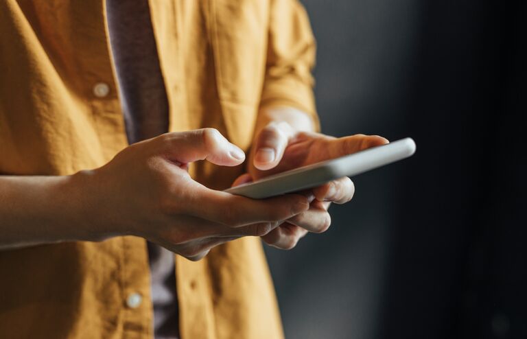 Anonymous Man Wearing a Yellow Shirt Using Modern Technology, a Close Up