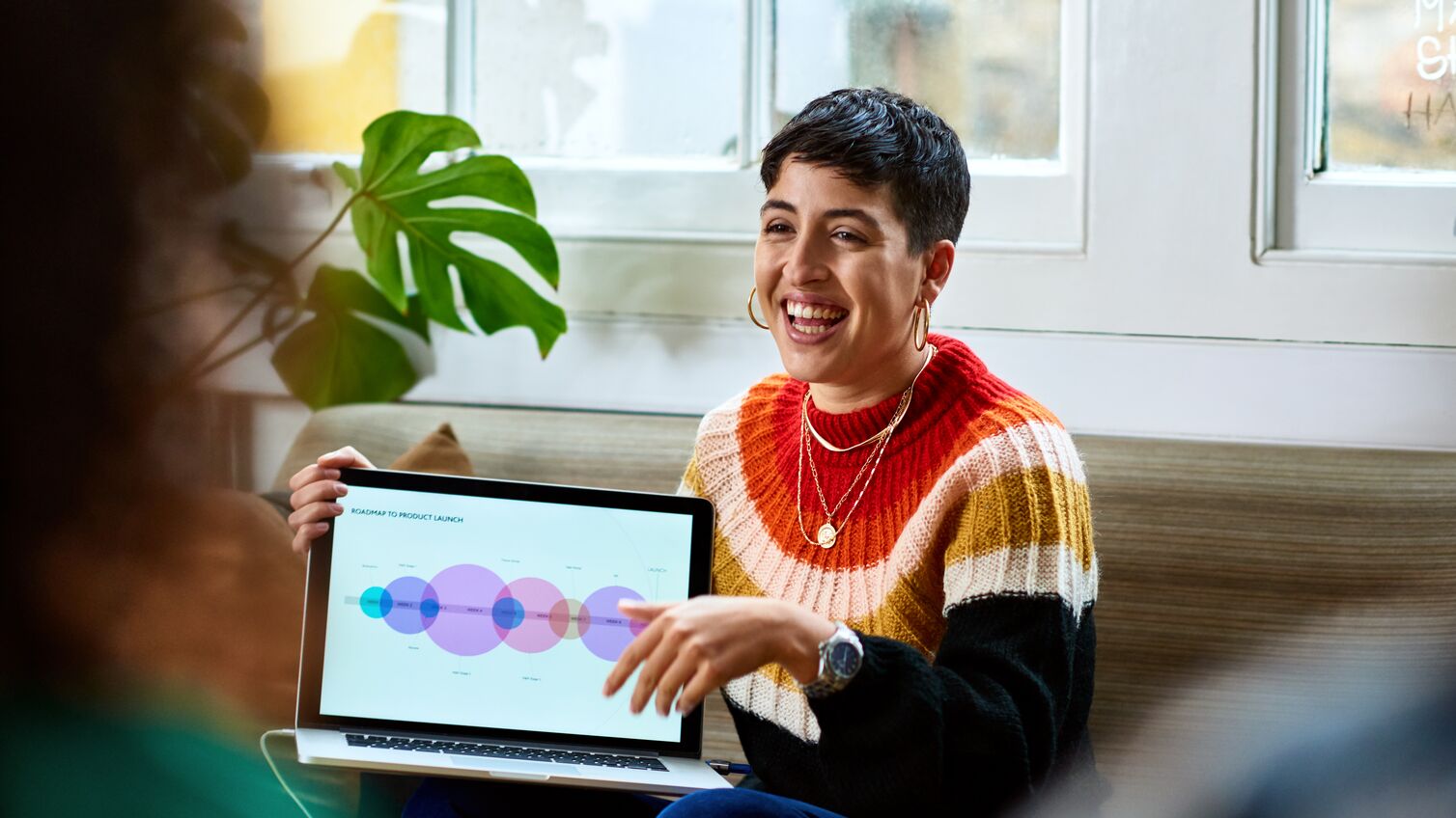 Hispanic woman sharing computer graphics with creative team, innovation, future, teamwork