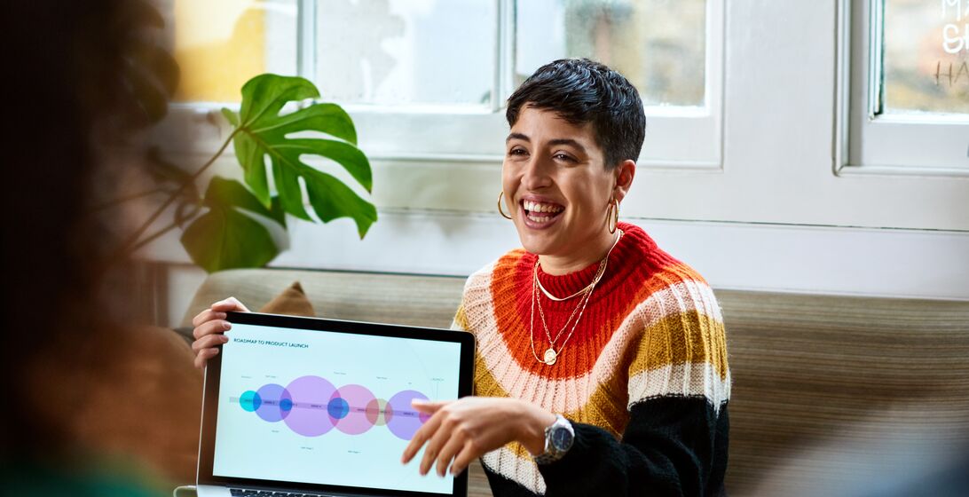 Hispanic woman sharing computer graphics with creative team, innovation, future, teamwork
