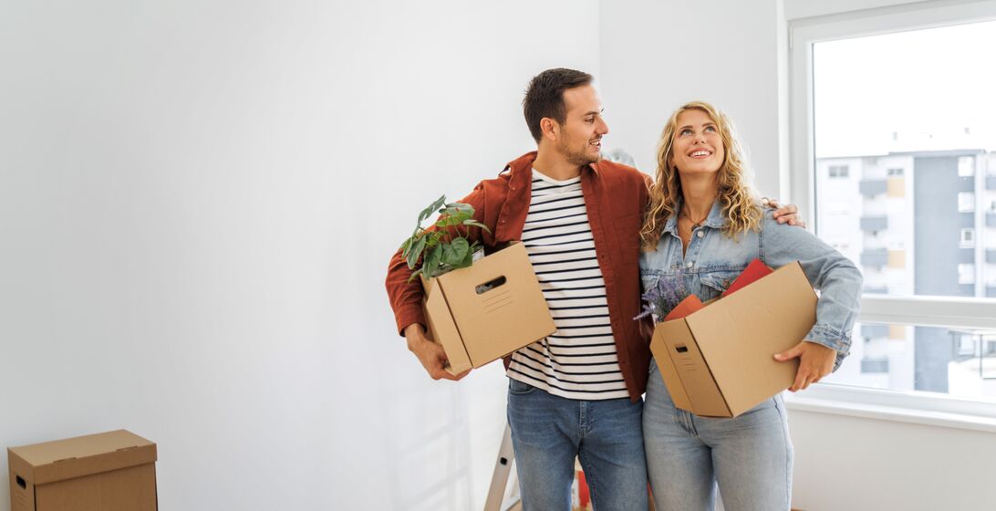 Young loving heterosexual couple embracing in their new home.