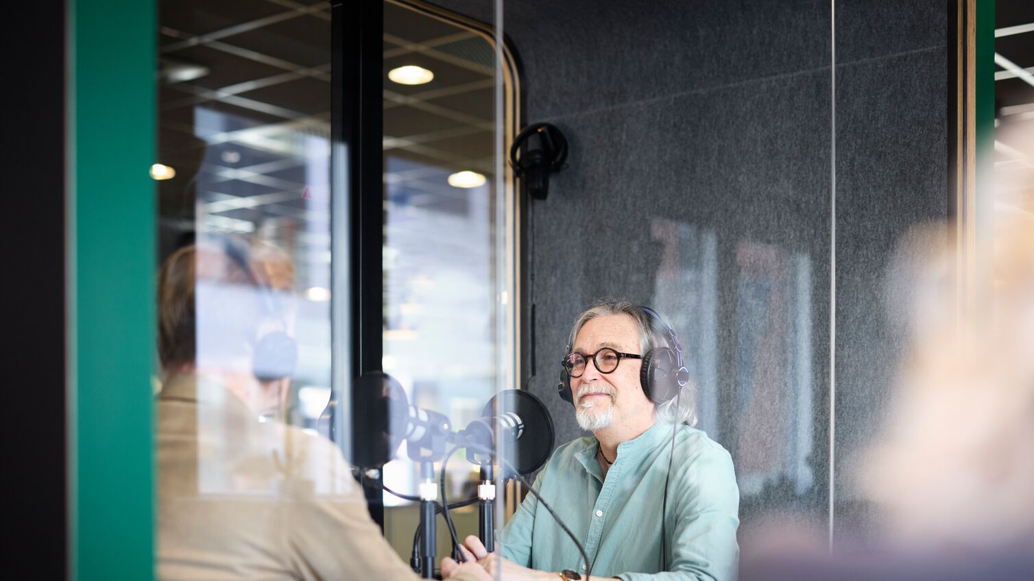 Male radio presenter talking with his guest on radio show or podcast