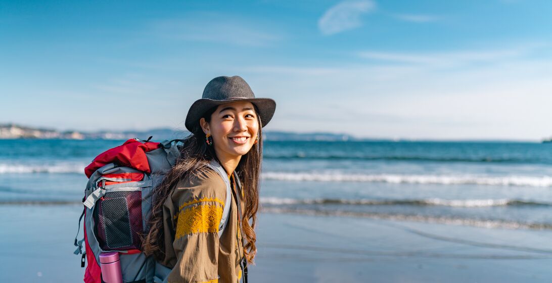 A young female traveller is enjoying spending time at the beach on her vacation.