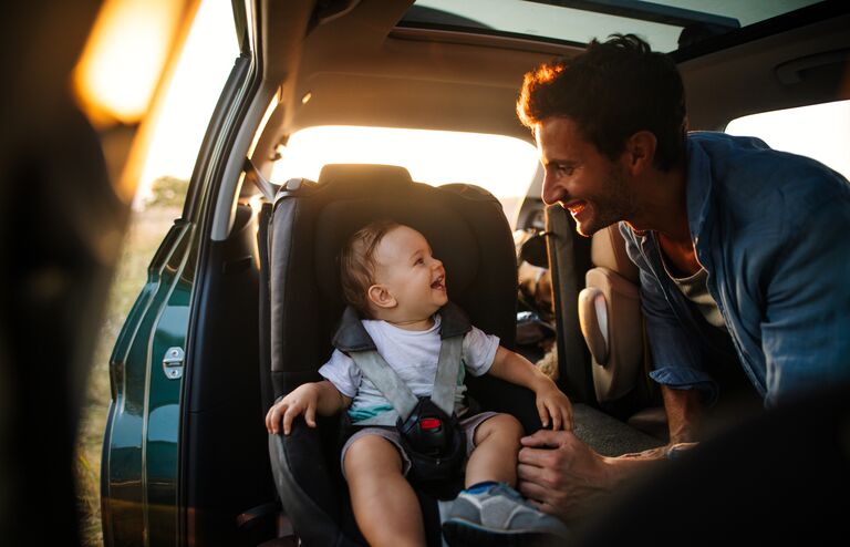 Photo of young father spending time with his son by taking him on a road trip in nature
