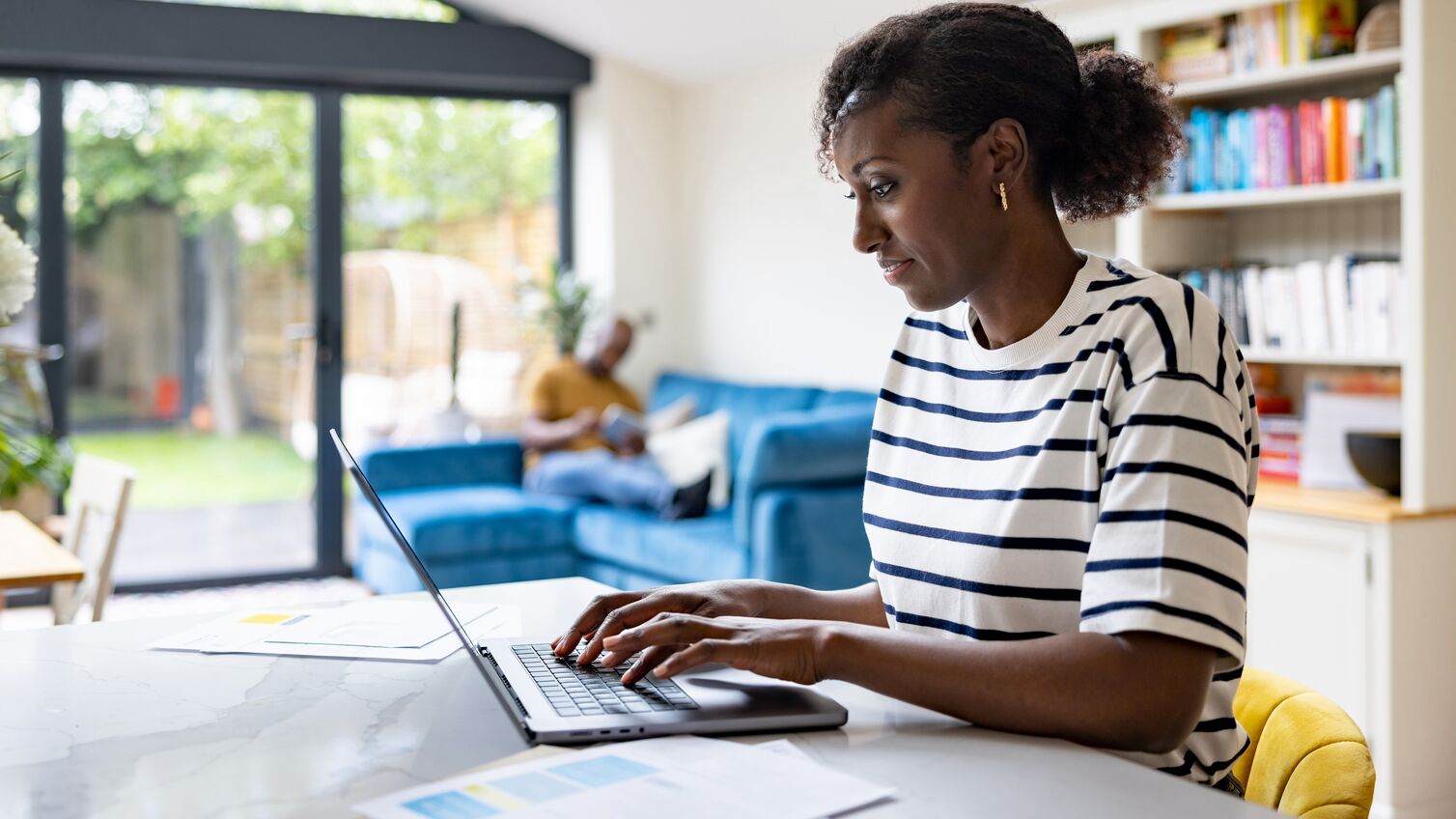 Happy black woman working at home using her laptop computer - telecommuting concepts