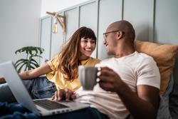 Young couple using the laptop in the bed at home