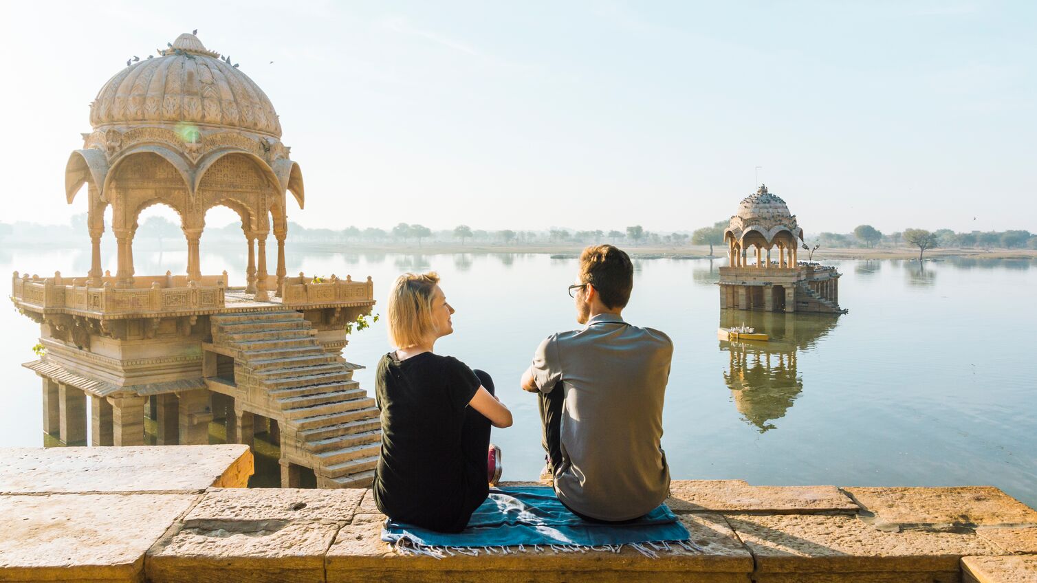 Gadi Sagar lake; she is at a public viewpoint, accessible without entry fee