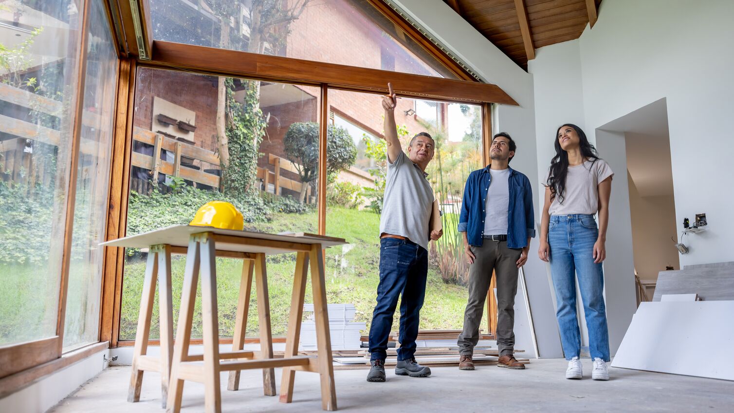 Latin American building contractor talking to clients renovating their house and sharing ideas
