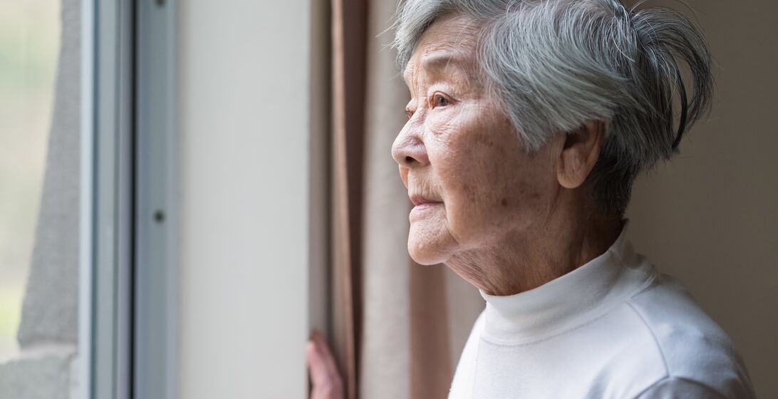 Chinese senior woman looking outside.