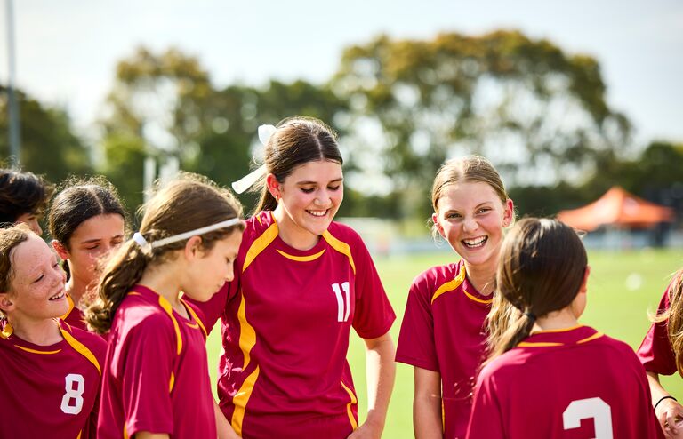 Girls' soccer team giggling as they are having fun