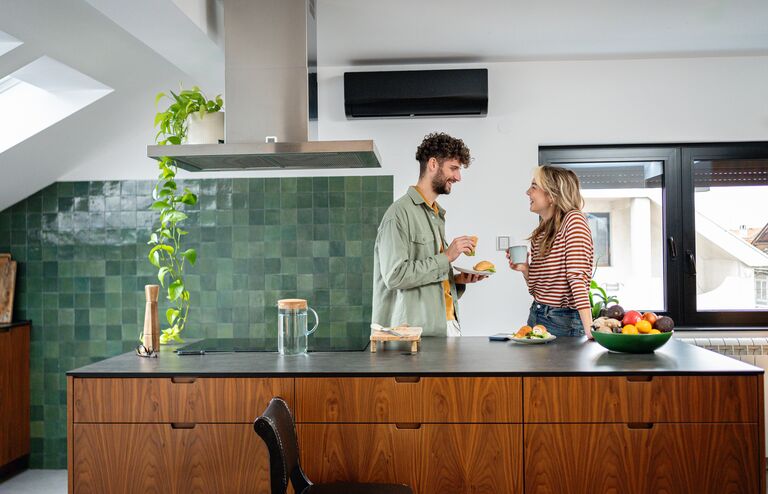 A young couple spends a nice morning at home while having breakfast and drinking coffee in the kitchen