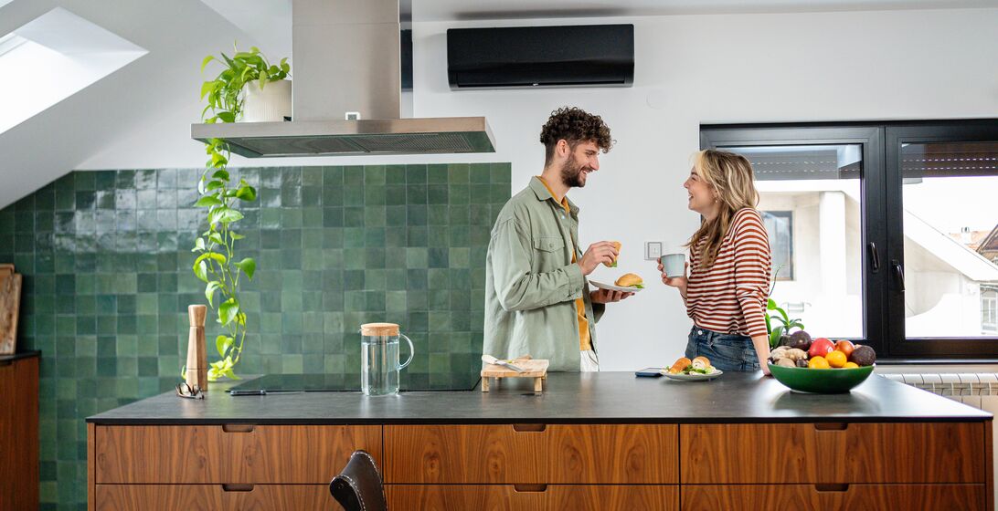 A young couple spends a nice morning at home while having breakfast and drinking coffee in the kitchen