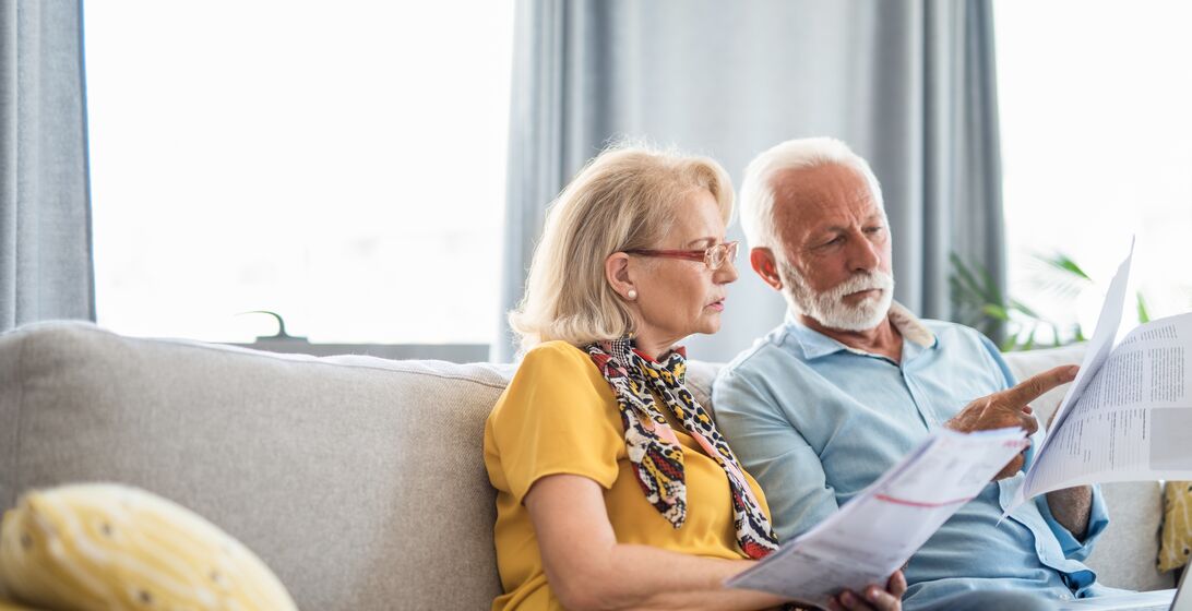 Serious senior husband and wife paying home expenses.