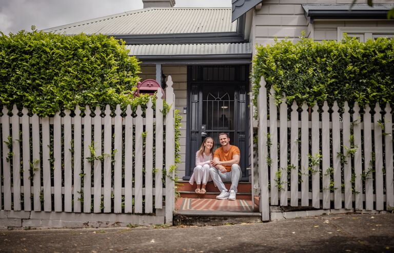 Couple sitting on the front steps of their house