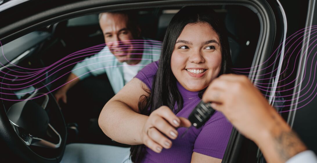 Woman purchasing a new car and receiving their new keys.