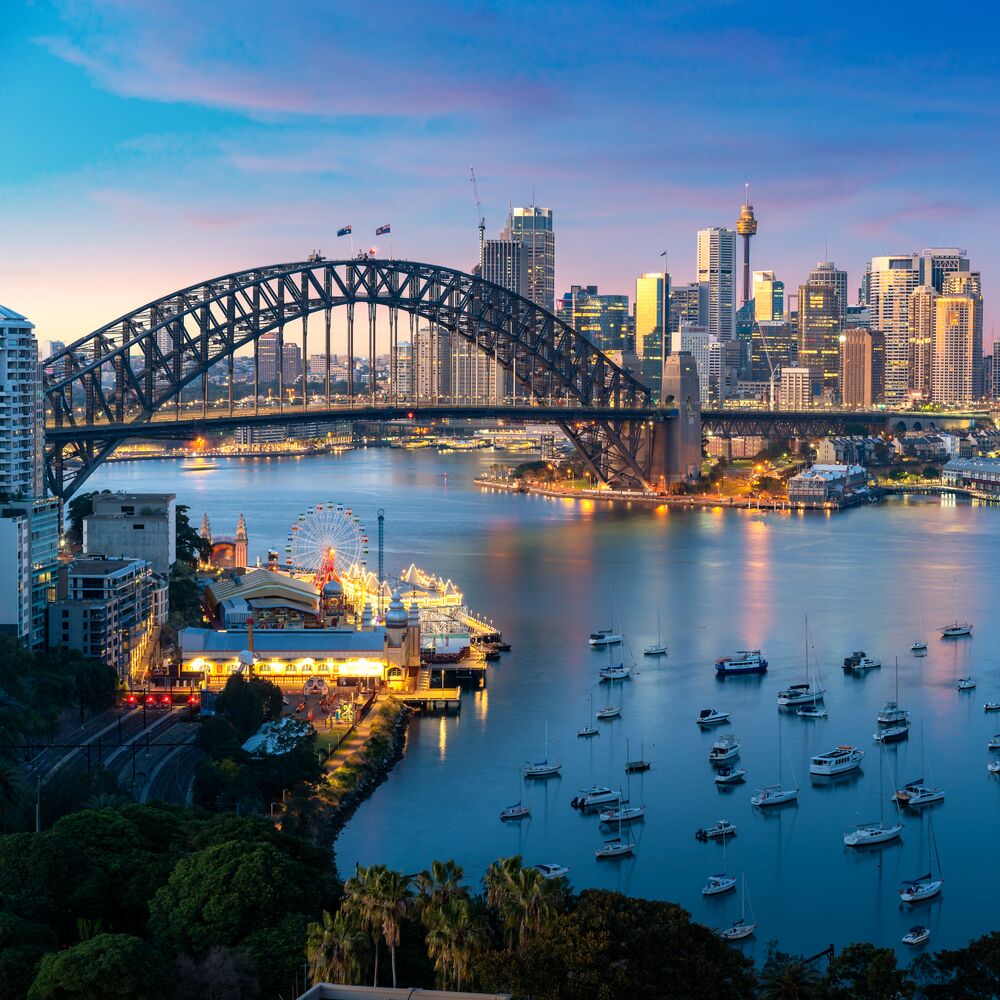 Cityscape image of Sydney, Australia with Harbor Bridge and Sydney skyline during sunset. Vacation and travel in Australia.