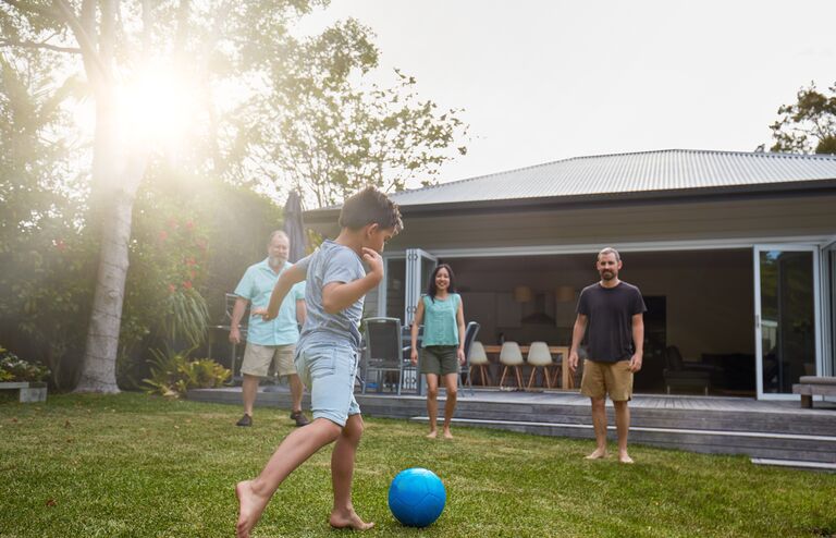 Australian family playing in the back yard garden at sunset.
