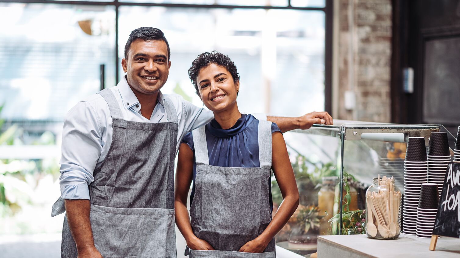 Baristas, bartenders, waiters and other restaurant staff expressing positivity and professional attitude when serving their customers. Portrait of waiters or bartenders enjoying working in modern drink establishment.