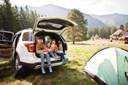 Family of four kids at vehicle interior. Children sitting in trunk. Traveling by car in the mountains, atmosphere concept.