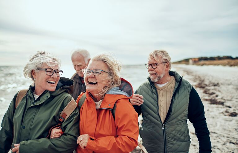 Close up of a group of seniors taking a walk by the beach