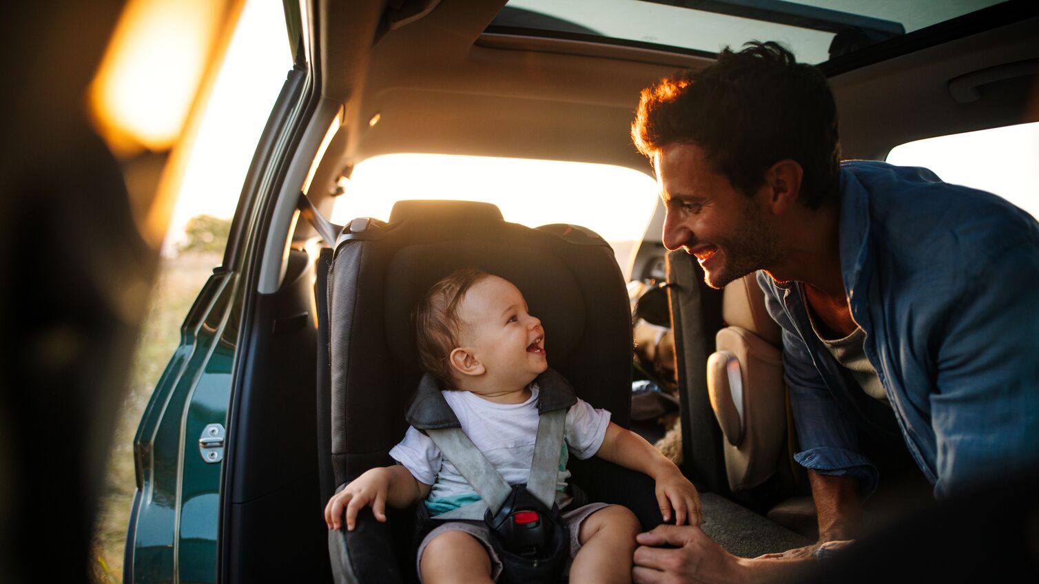 Photo of young father spending time with his son by taking him on a road trip in nature