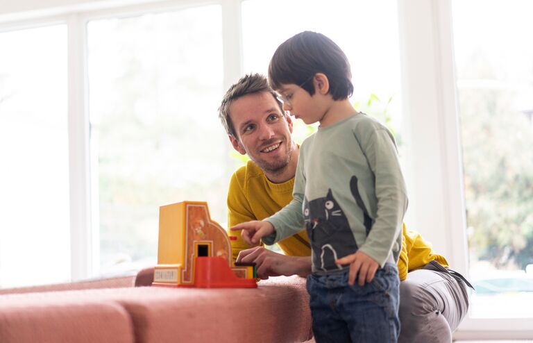 Father and son playing with a toy till