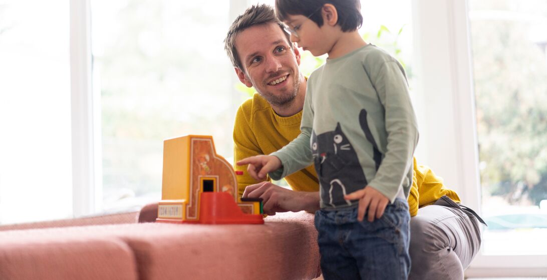 Father and son playing with a toy till