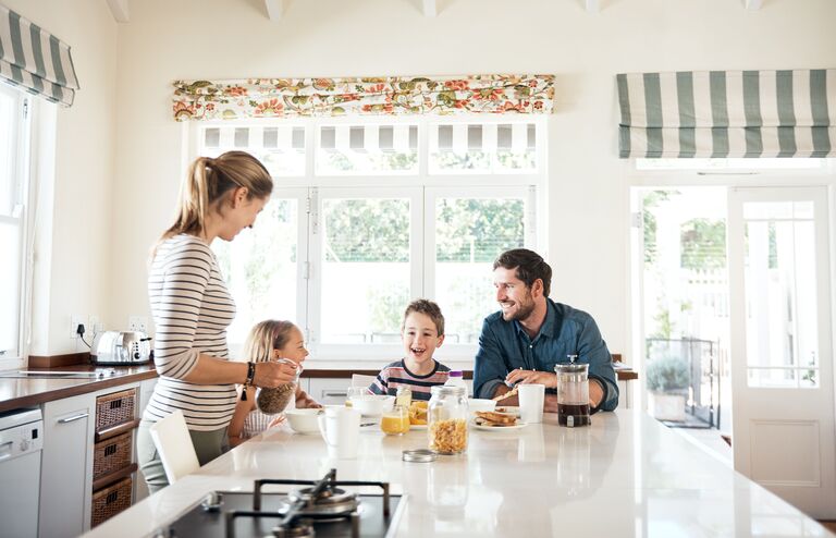 Shot of a happy family of four having breakfast together in the kitchen at home