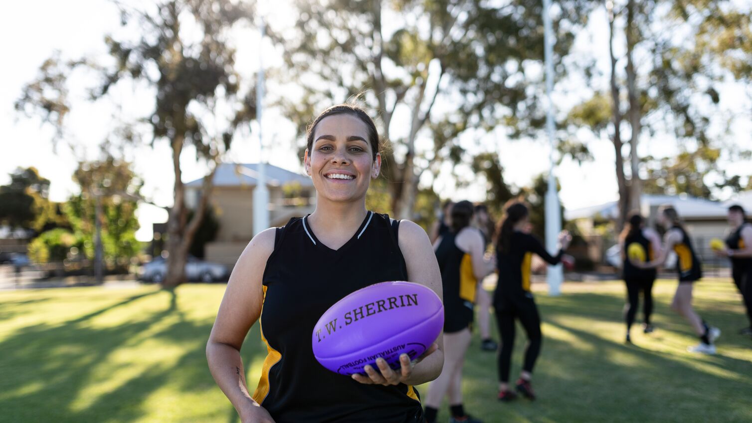 A young woman holding a football.