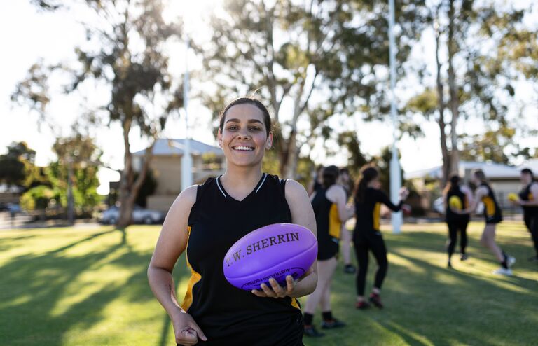 A young woman holding a football.