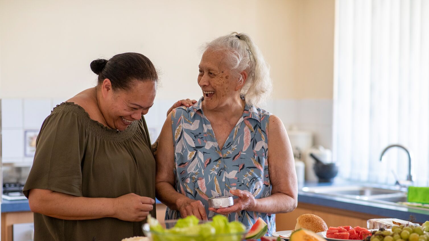 Senior Pacific Islander woman and her mature daughter preparing food together in their kitchen at home.