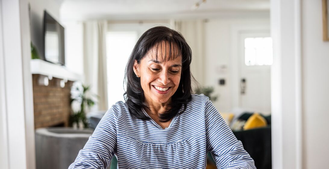 Senior woman using smartphone  in dining room