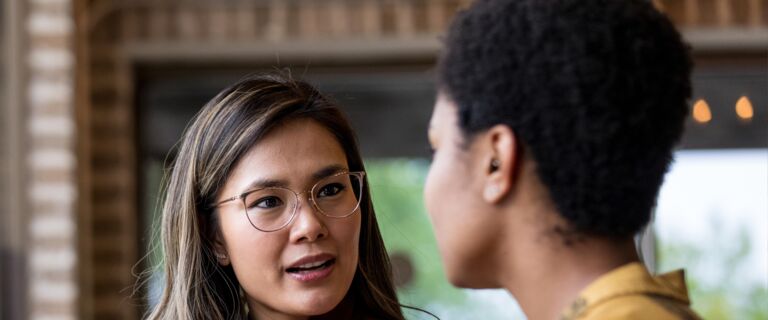 Two people having a conversation in a coffee shop.