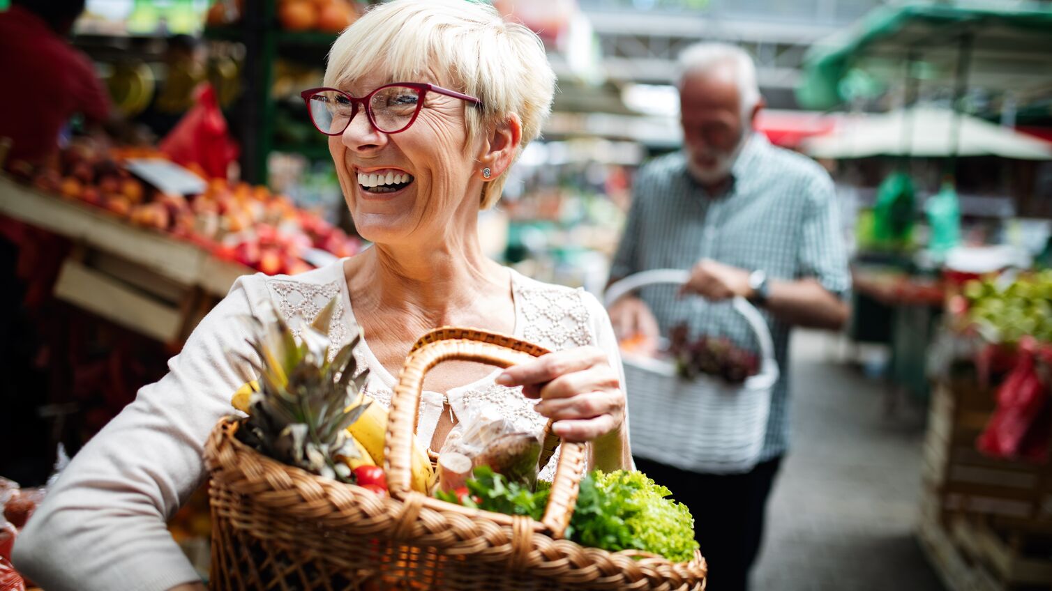 Senior couple buying fresh vegetables at the local market