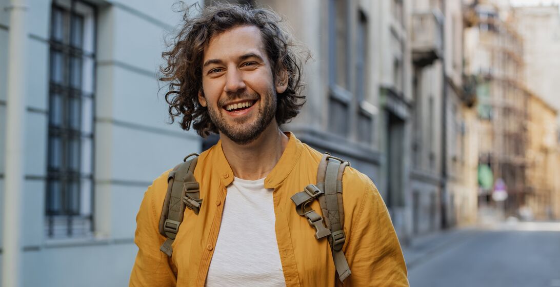 Young man walking on the street and smiling